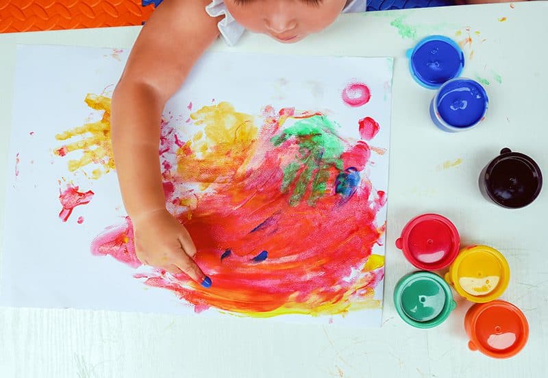 A child finger painting at Kids Discovery