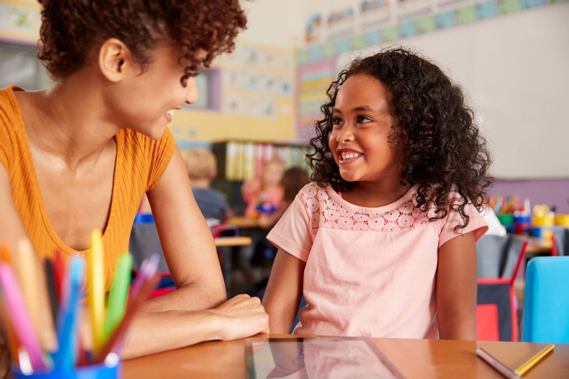 A teacher and a child smiling at each other in a Kids Discovery classroom